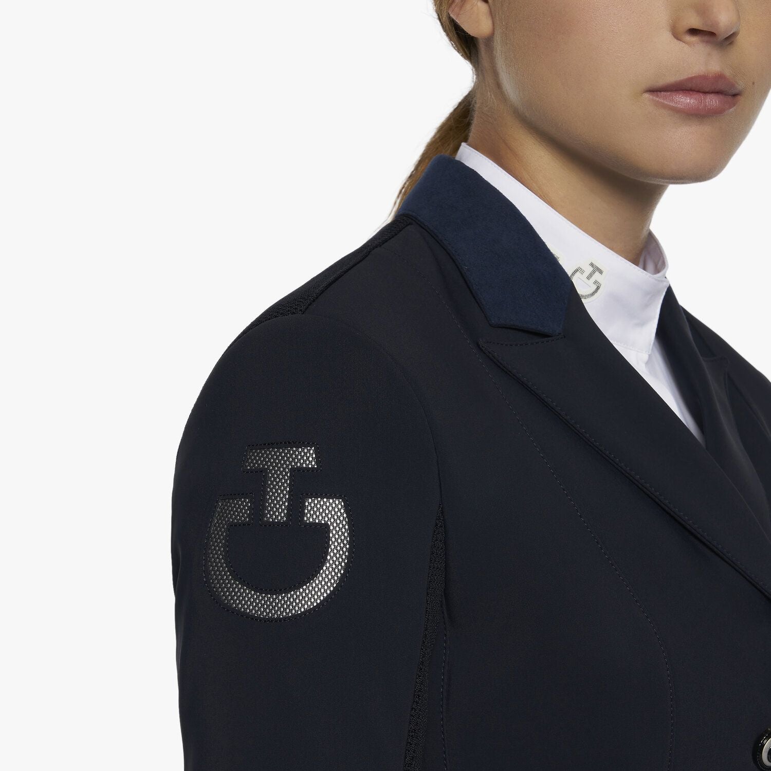 The tailcoat is refined by alcantara collar, piping and points, while the metallic buttons are refined by a logo. Bottom tails include removable weights for greater stabilty and elegance during performance. The look is completed by a functional front pocket and an embroidered logo on the shoulder. 